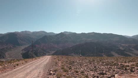 toma de adelantamiento de un accidente automovilístico junto a un camino de tierra con fondo montañoso, norte de argentina