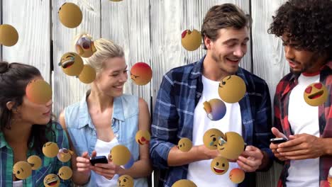 Emoji-Symbole-Mit-Einer-Gruppe-Von-Freunden,-Die-Smartphones-Im-Hintergrund-Nutzen