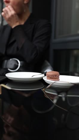 woman enjoying macarons in a cafe