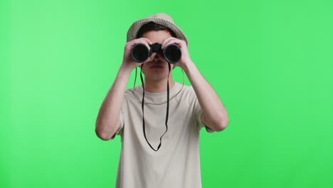 man looking through binoculars on green screen