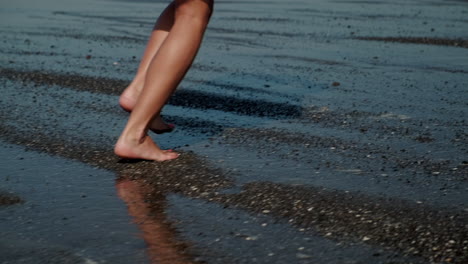 woman walking barefoot on the wet beach