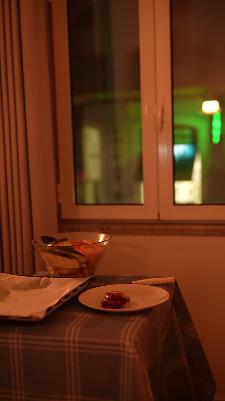 Preparing a meal at home by the window at night