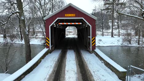 aerial flyover of a snowy covered bridge