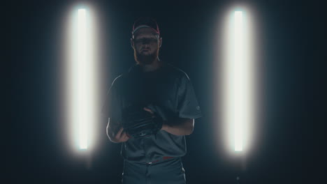 Caucasian-professional-baseball-player-pitcher-throwing-a-ball-towards-camera-against-dark-background.-4K-UHD-60-FPS-SLOW-MOTION