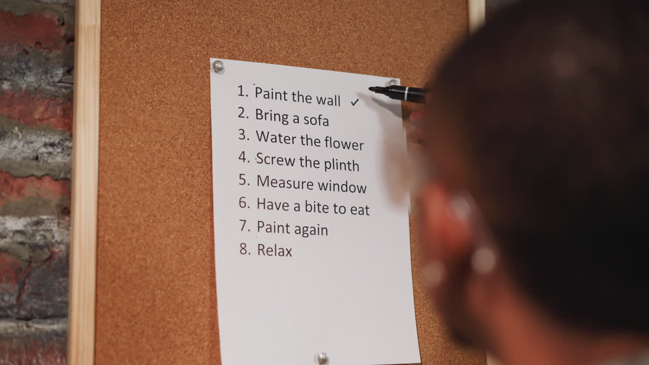 Black repairman marks accomplished to-do list items on board
