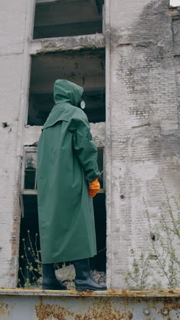 man in special radioactive uniform walking down. man wearing green chemical suit and gas mask. vertical video