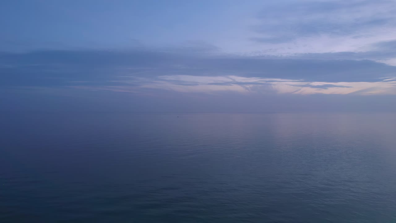 흐린 하늘과 일몰 후 잔잔한 파도