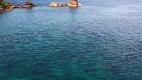 Mahe-Seychelles,-drone-shot-over-ocean-view-of-granitic-rocks,-turquoise-water