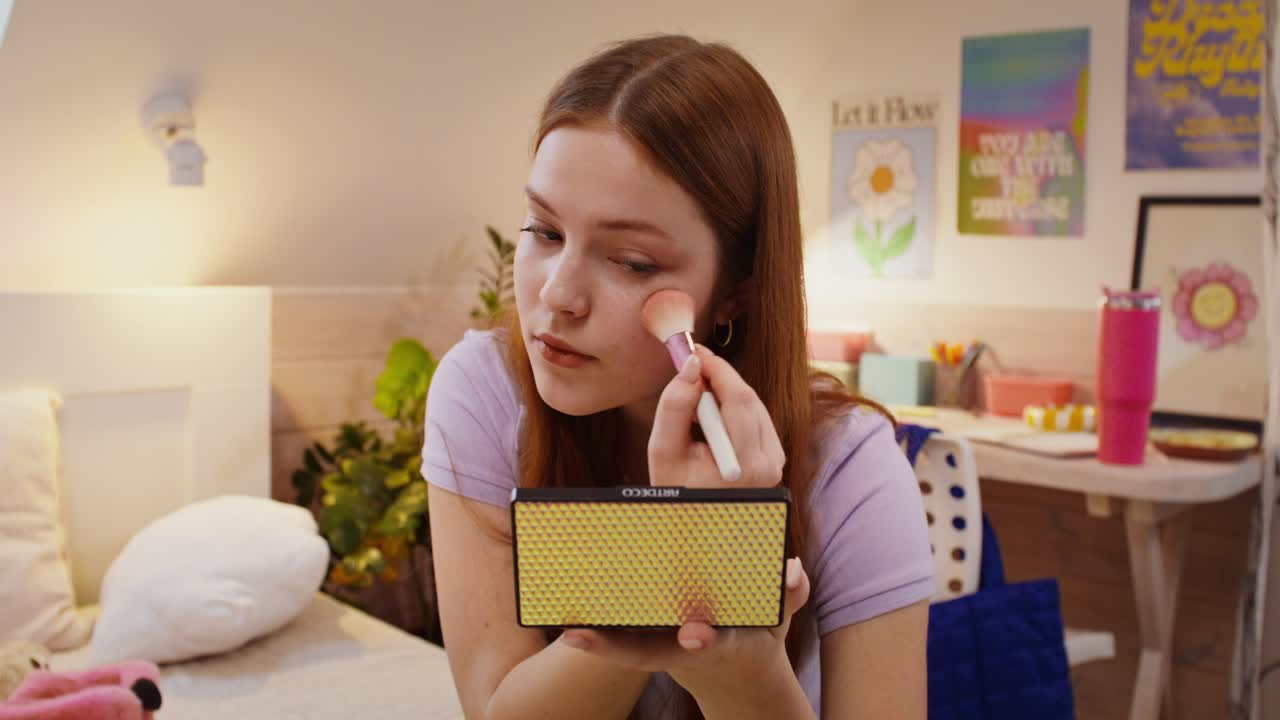 una adolescente aplicando maquillaje en su dormitorio