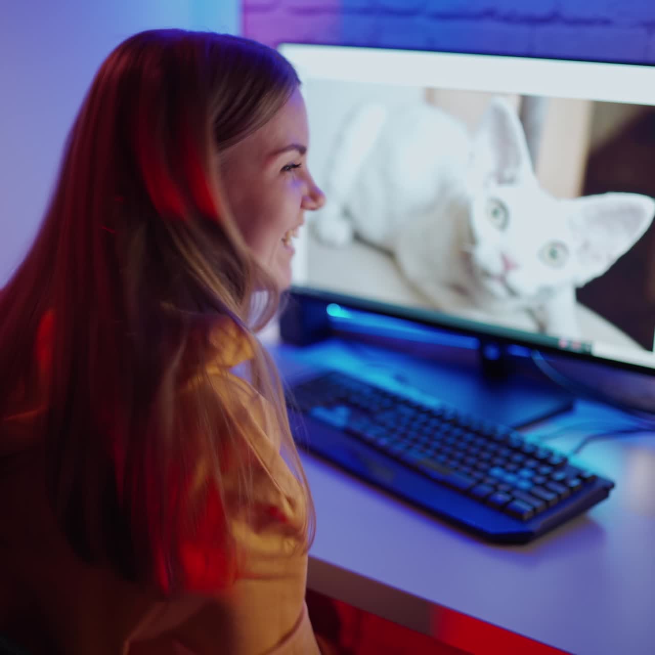 . Girl using computer in her house. Rear view of happy young woman using computer