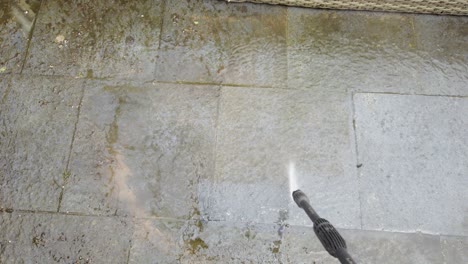 cleaning paving stones in backyard using high pressure water cleaner