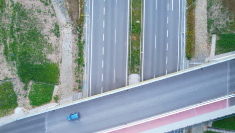 一架藍色汽車在白天穿過橋道上的空中上下射擊 - - 在<unk>石高速公路上方