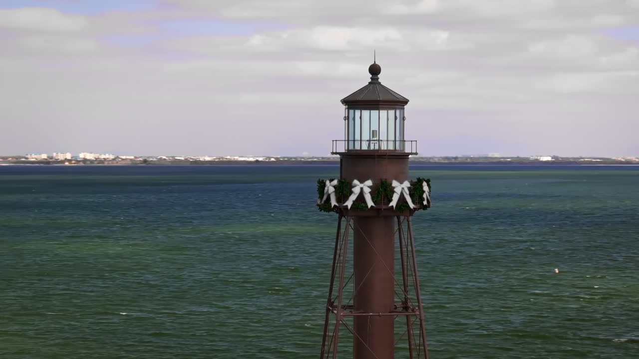 Florida, Sanibel Adası'nın doğu ucundaki tarihi Sanibel Adası Deniz Feneri'nin, Fort Myers yakınlarındaki parlak kıyı şeridiyle birlikte çekilmiş sinematik 70mm hava drone görüntüsü.