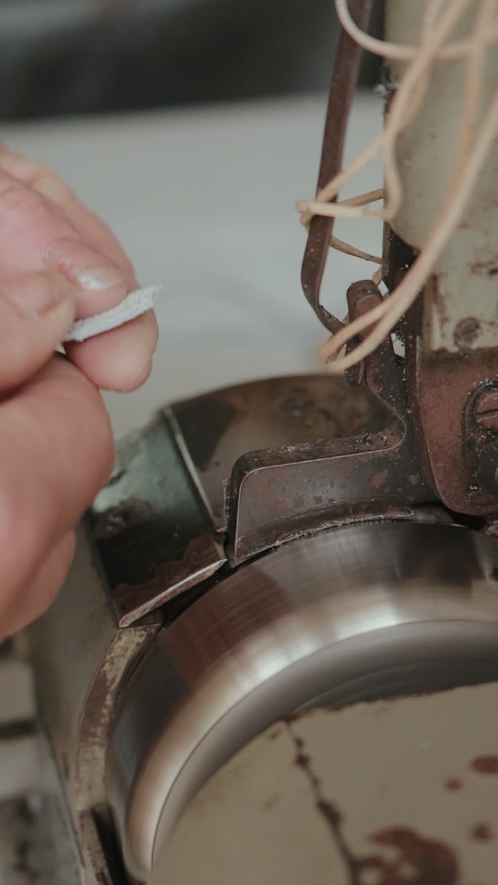 Vertical closeup of artisan processing leather parts for footwear production