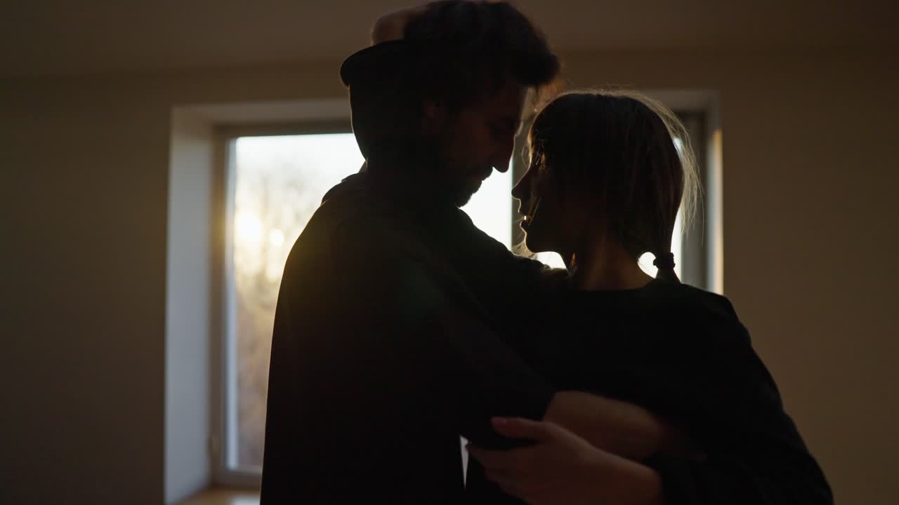 Couple embracing by the window