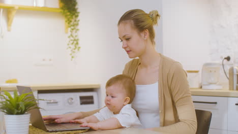 Junge-Frau,-Die-Am-Laptop-Arbeitet,-Während-Sie-Zu-Hause-Mit-Dem-Kleinen-Jungen-Sitzt-3