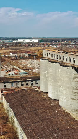 flight over the destroyed factory. old industrial building for demolition. aerial view vertical video