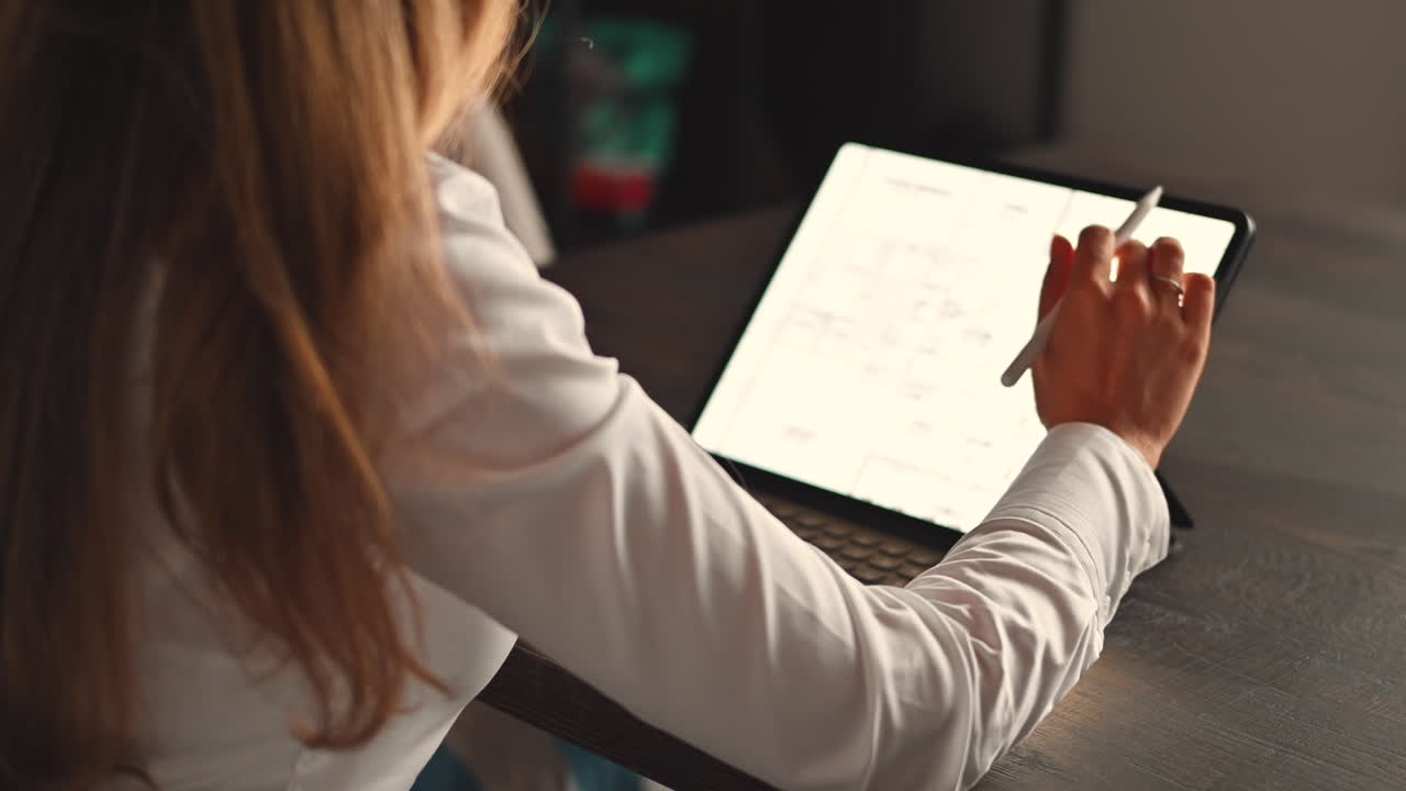 Woman working on a tablet with a stylus pen at an office