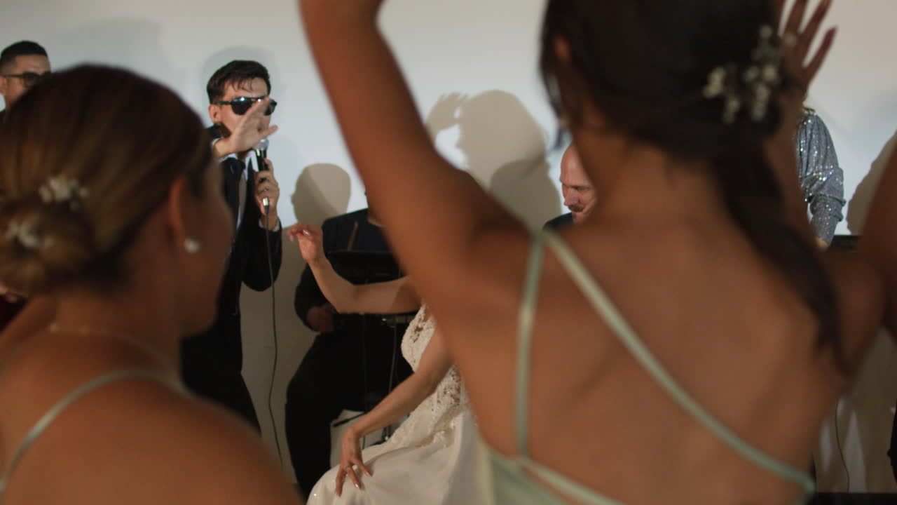 Clip of a wedding where the newlyweds dance happily with their guests and bridesmaids.