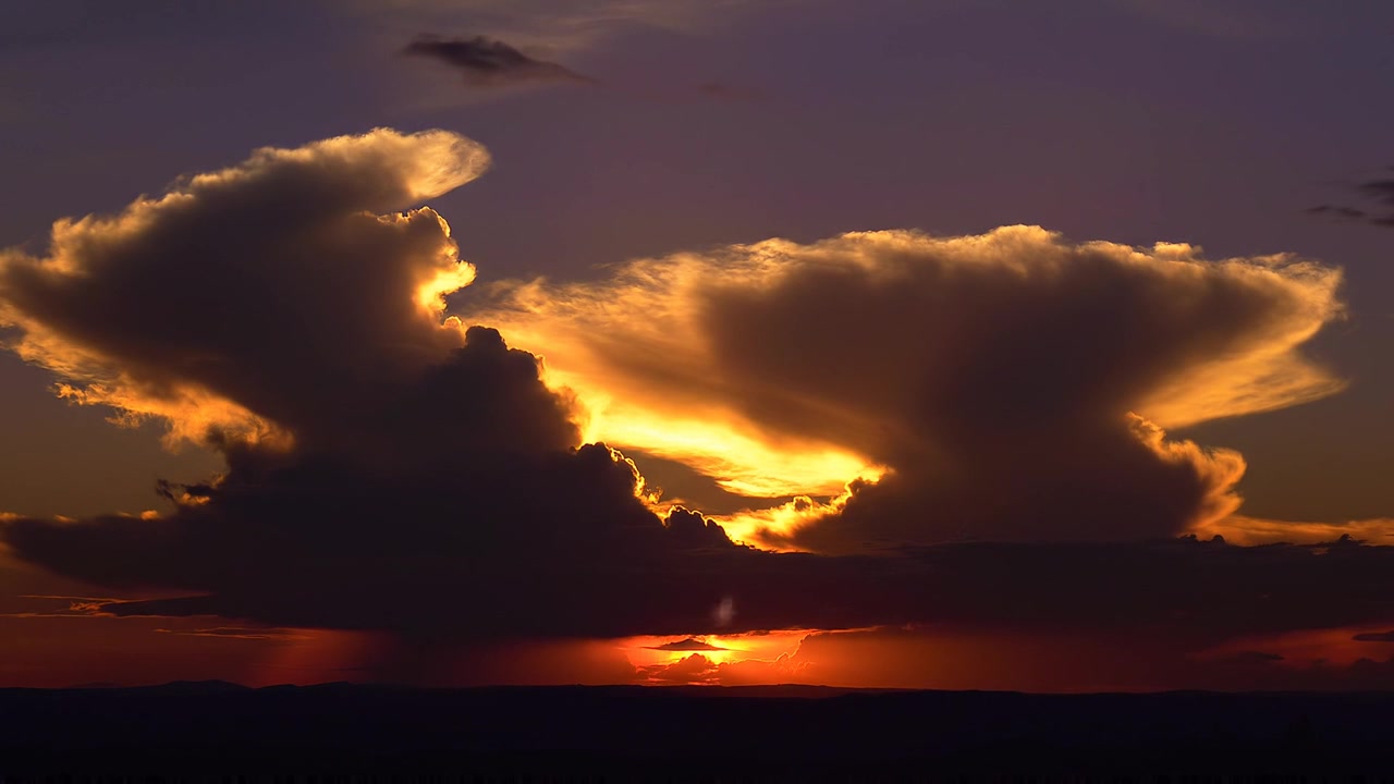 Dramatic sunset illuminating majestic storm clouds at golden hour