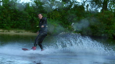 man riding wakeboard on motorboat wave. rider in training wake boarding