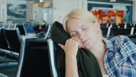 a young woman fell asleep in the airport terminal flight delay or cancellation concept