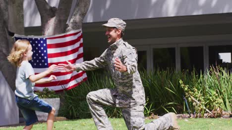 caucasian son hugging his military dad in uniform in the garden