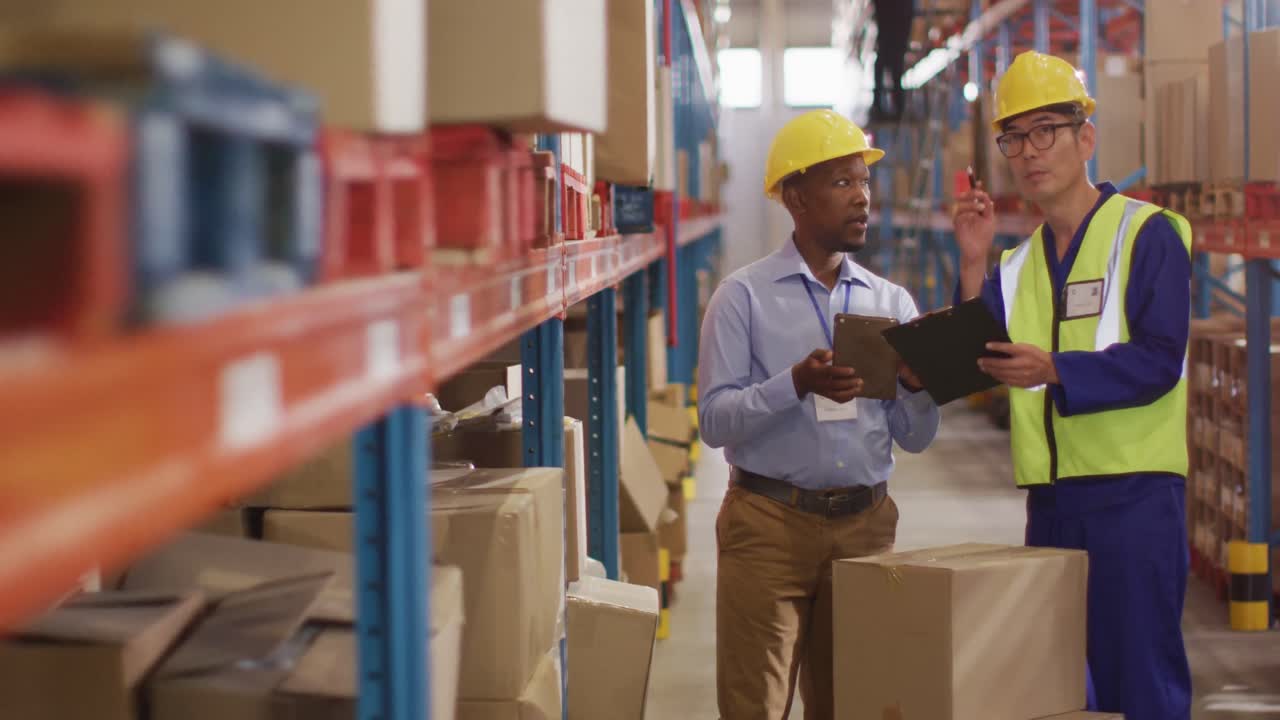diversos trabajadores varones con trajes de seguridad y hablando en el almacén