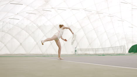 WIDE-SIDE-VIEW-Young-Caucasian-female-tennis-player-hitting-a-ball-during-game-or-practice.-100-FPS-slow-motion,-4K-UHD-RAW-graded-footage