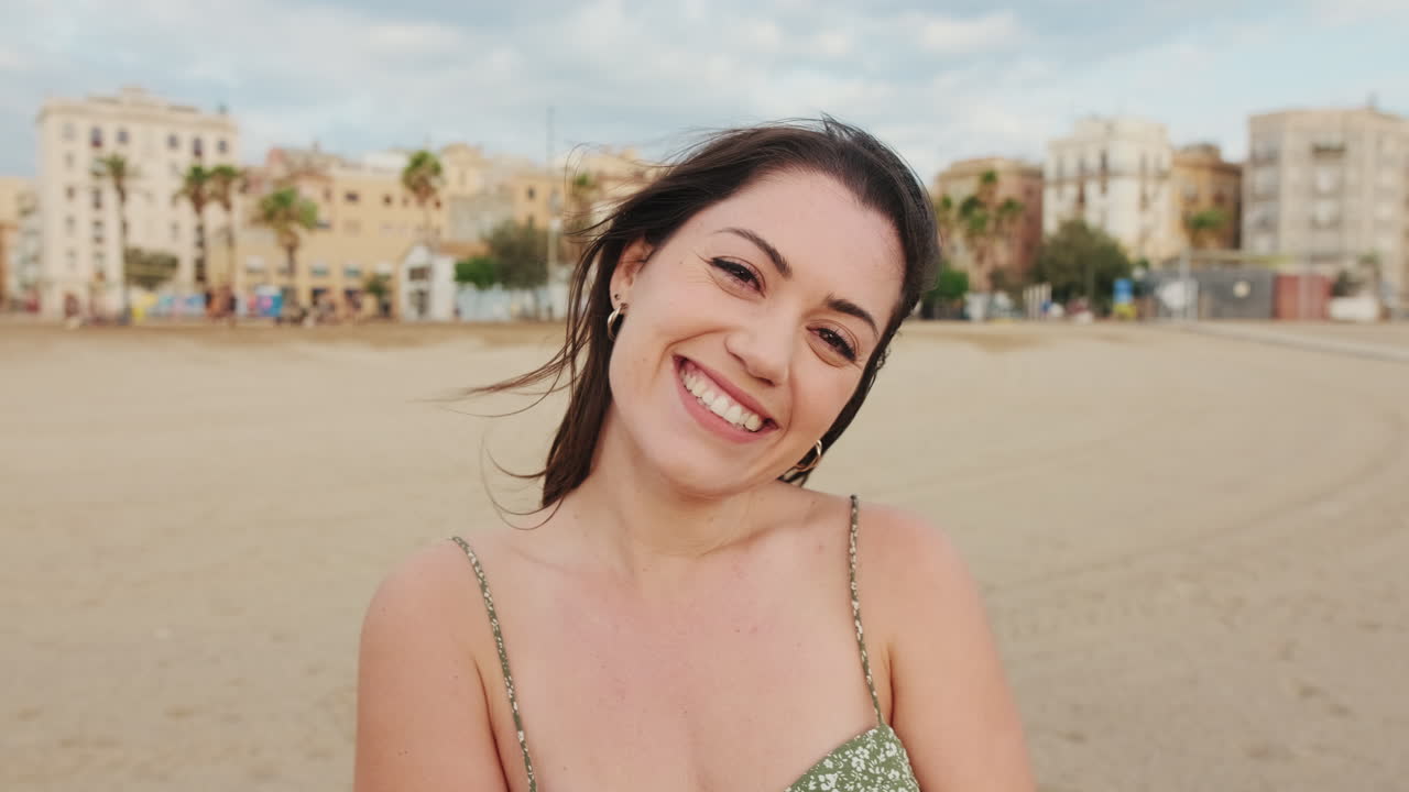 Woman on a beach with a cityscape in the background