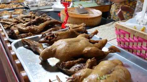 close-up footage of street food vendor displaying chinese stewed duck on stainless tray