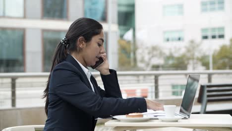 young businesswoman with digital devices in cafe