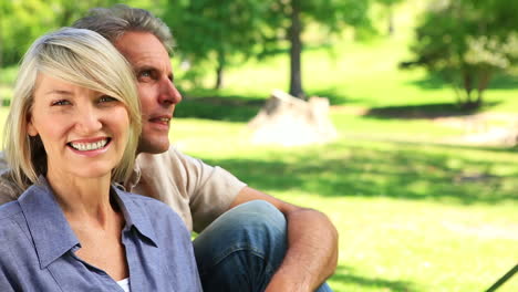 Happy-couple-sitting-in-the-park