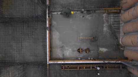 top down aerial view of construction workers laying wet cement, israel