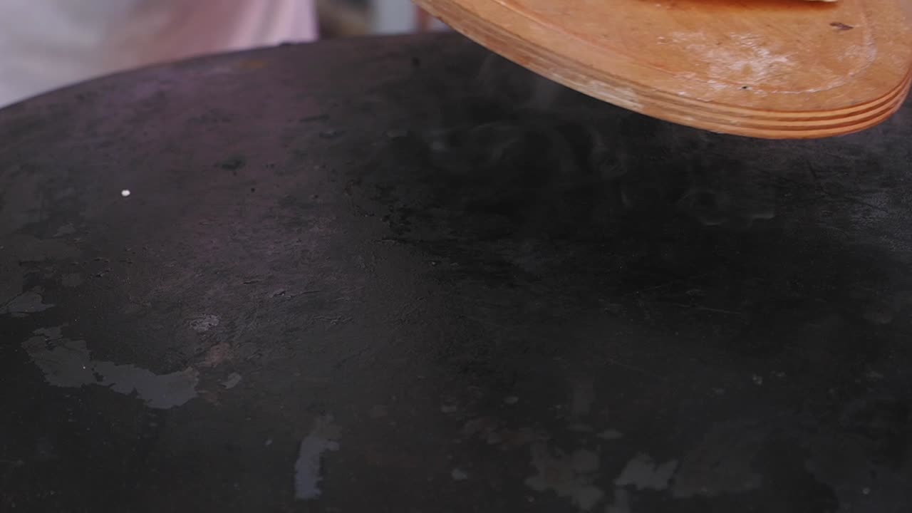 preparando pan plano turco en una parrilla