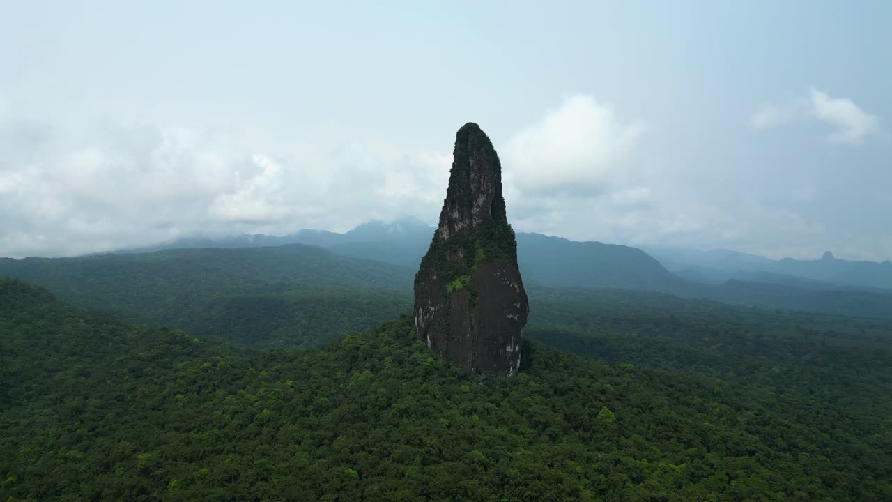 Panoramic drone shot circling the Pico Cao Grande mountain, in Sao Tome, Africa