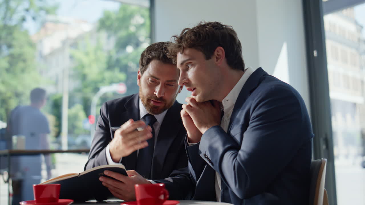 Two startupers working remotely at coffee house closeup. Active manager calling