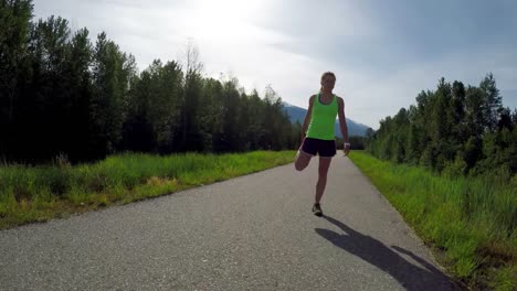 fit woman doing stretching exercise in road 4k