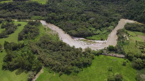 Aerial-view-of-a-swollen-curvy-river-in-Lima,-Peru,-caused-by-landslides-and-heavy-rainfall