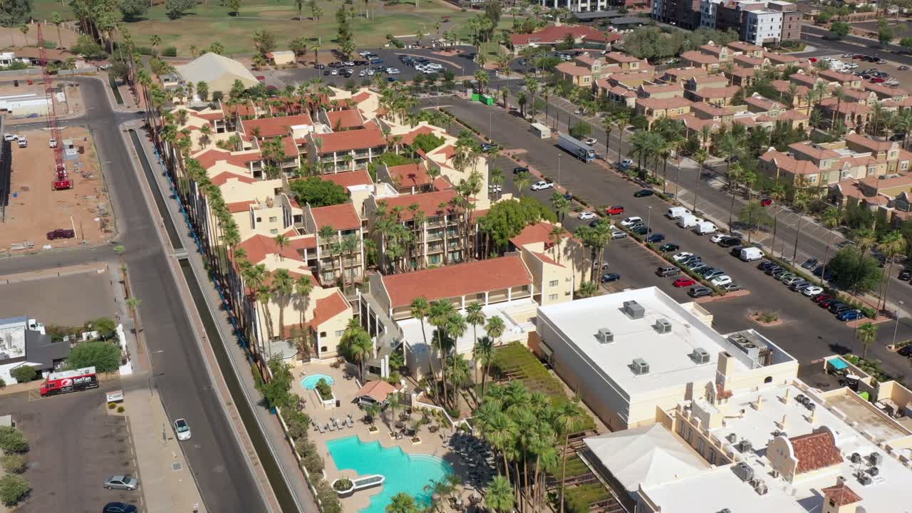 el centro de chandler muestra edificios coloridos, calles, coches y una zona de piscina vibrante, vista aérea