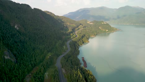 Aerial-view-of-Trans-Canada-highway-and-Howe-Sound-with-logging-wood-floading,-Squamish,-BC,-Canada