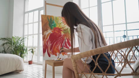 art student draws wonderful flowers on canvas in studio