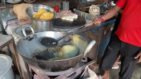 在街頭的dhaba中,<unk>師在火上用熱油炸和煮印度料理poori puri