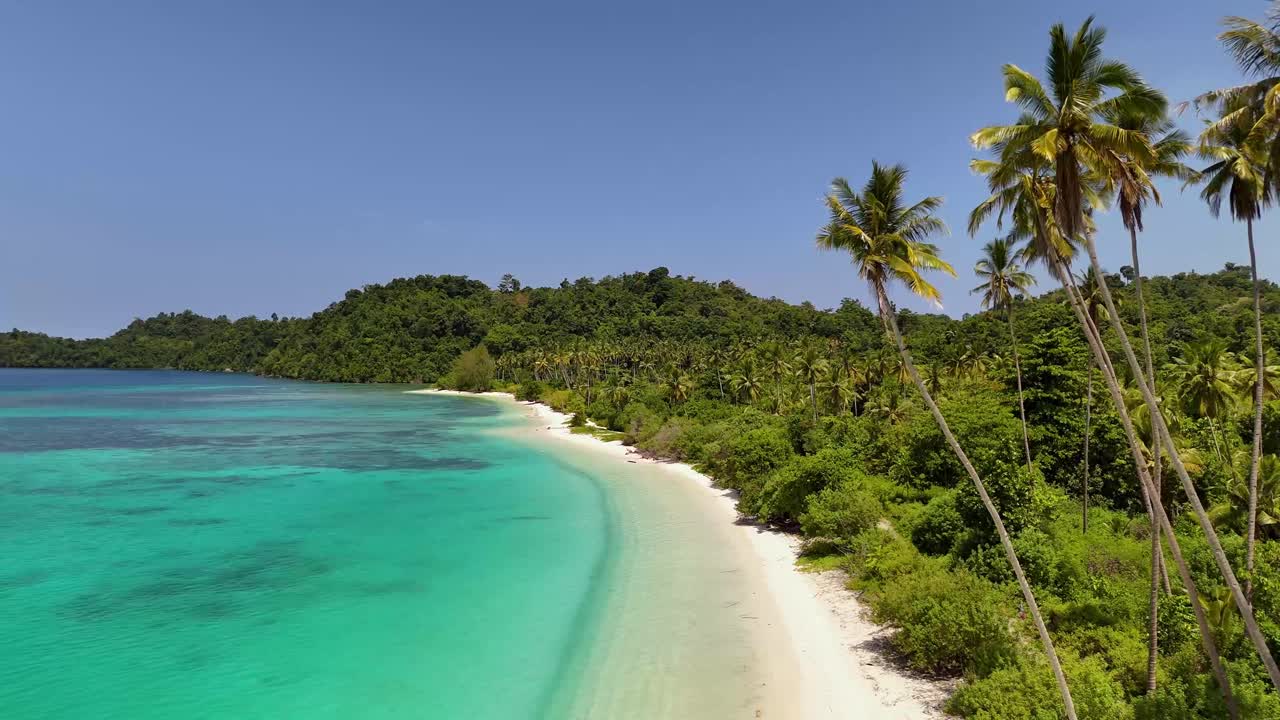 Video drone 4K di un paradiso tropicale, la spiaggia di Pompon, circondata da paesaggi tropicali e naturali, oceano blu cristallino e sabbia bianca e soffice nelle Isole Banggai, Sulawesi, Indonesia.