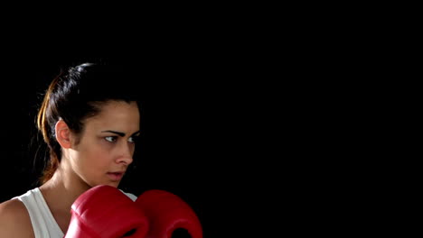 una morena golpeando con guantes de boxeo.