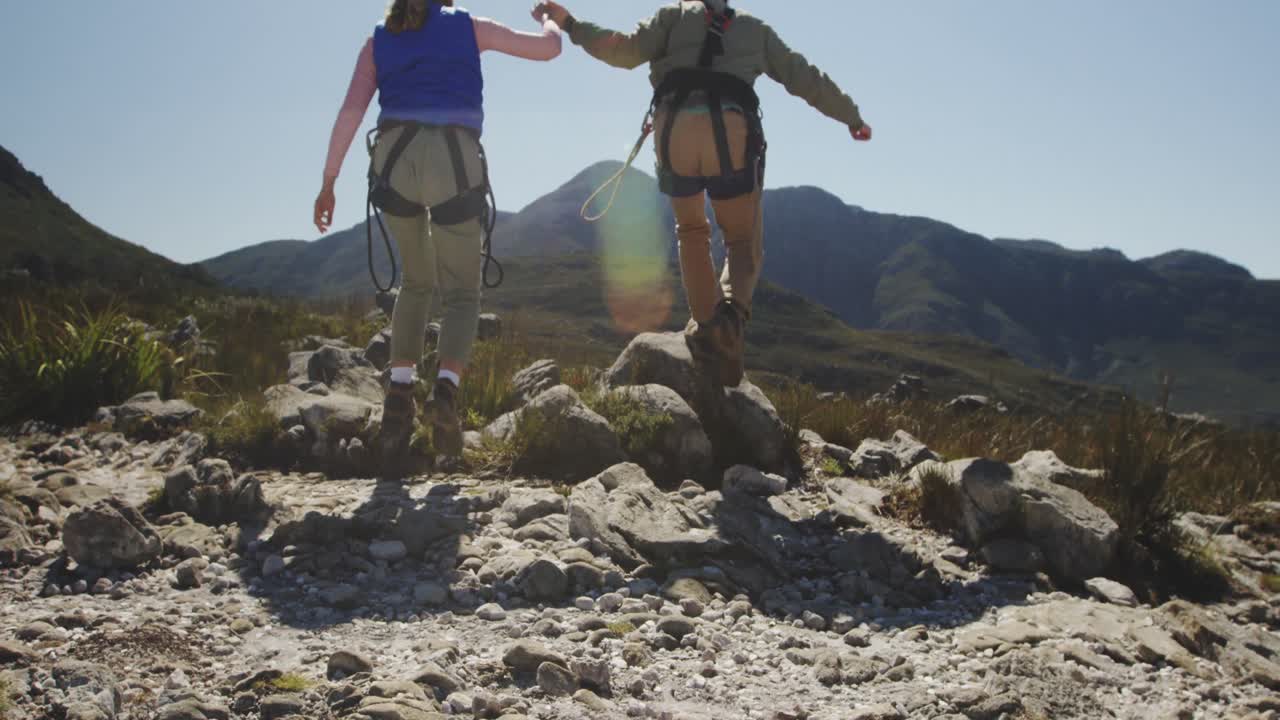 joven pareja caucásica corriendo en equipo de forro de tirolesa