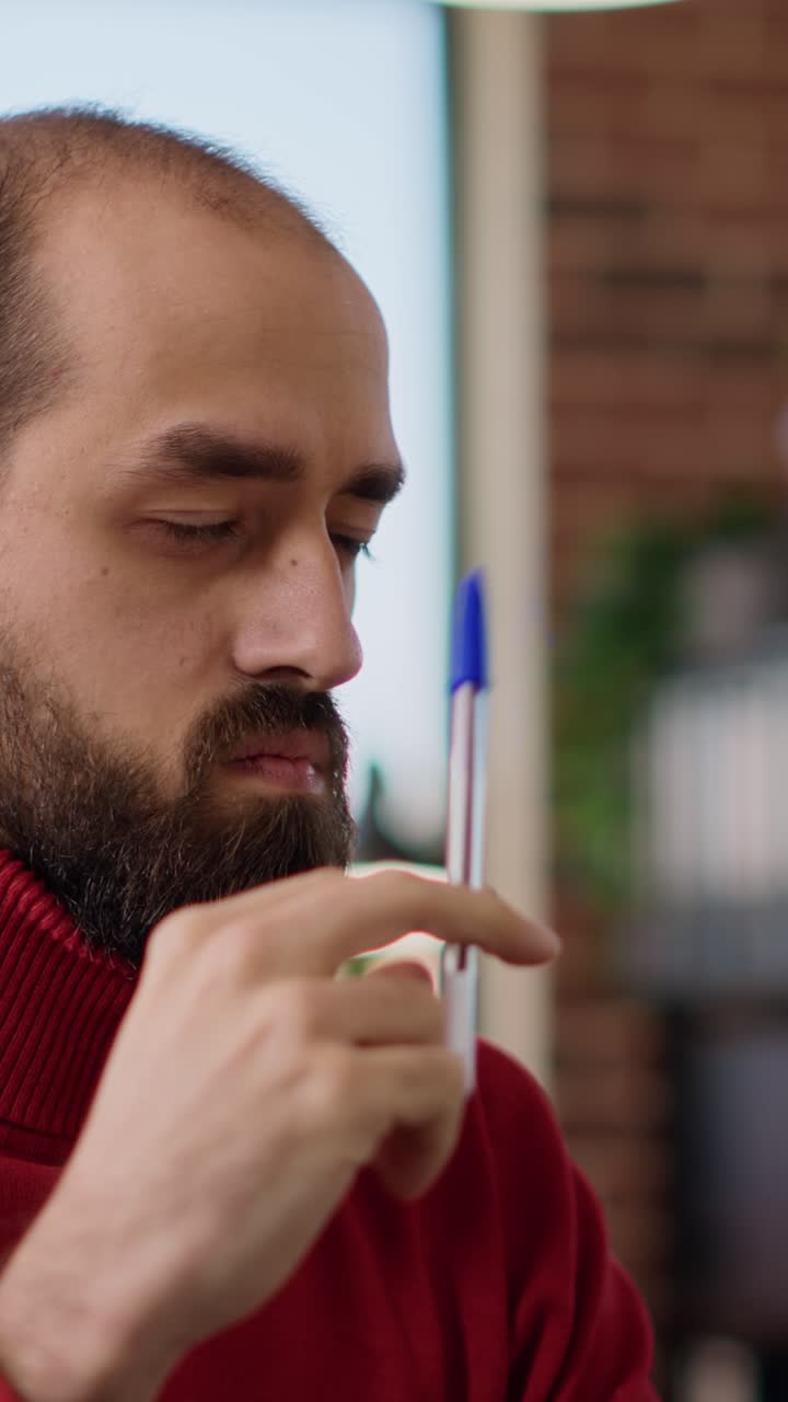 Uomo che pensa con la penna sulla fronte