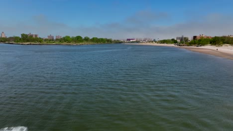 Una-Vista-Aérea-De-La-Bahía-De-Gravesend-En-Brooklyn,-Nueva-York,-Mientras-La-Gente-En-Motos-Acuáticas-Disfruta-Del-Hermoso-Día