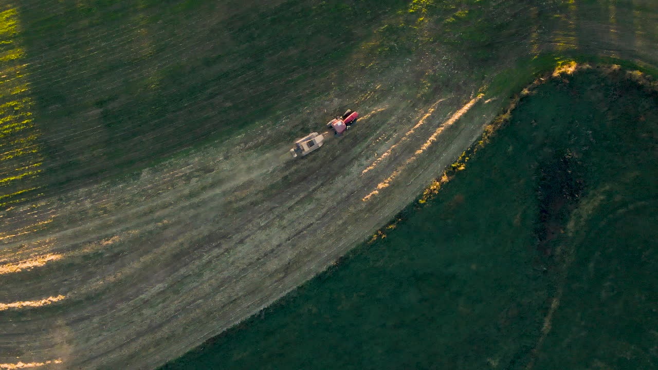 펜실베니아주 시골에서 늦은 오후에 나르는 기계를 당기는 트랙터의 하향식 공중