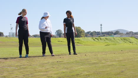 playing cricket, women discussing strategy on field during practice session